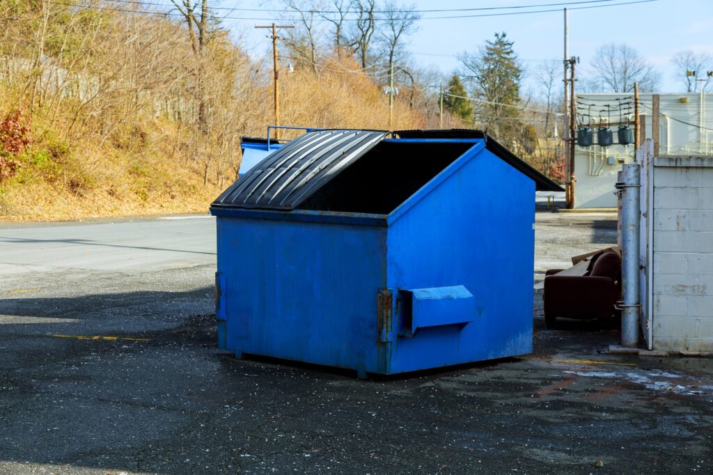 A traditional dumpster sitting in an alley